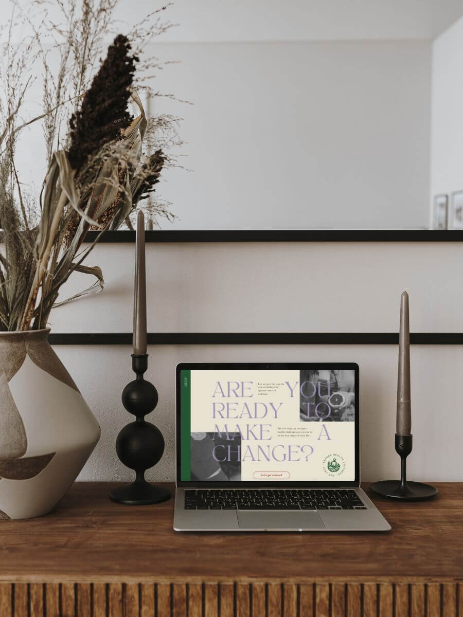 Open laptop on a stylish desk displaying the website homepage for Asana.