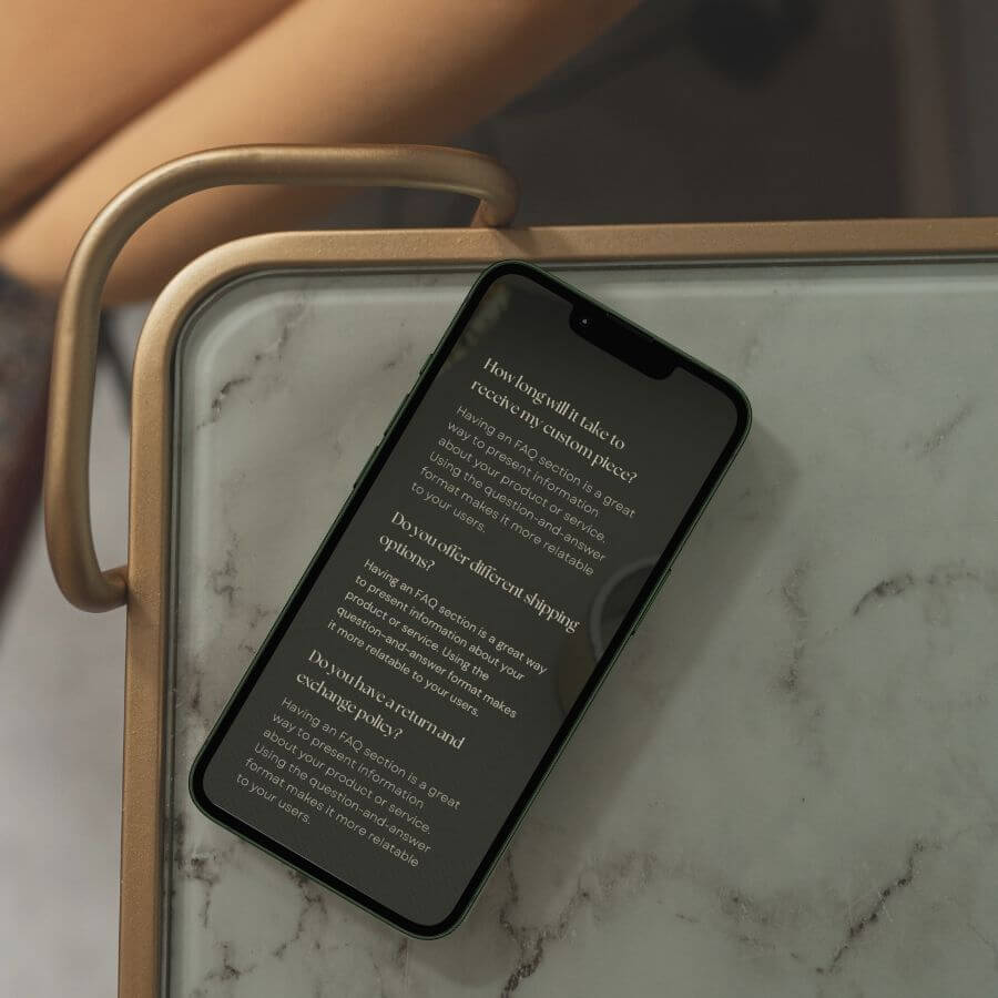 close up of iPhone on marble table, screen showing mobile version of text on website.